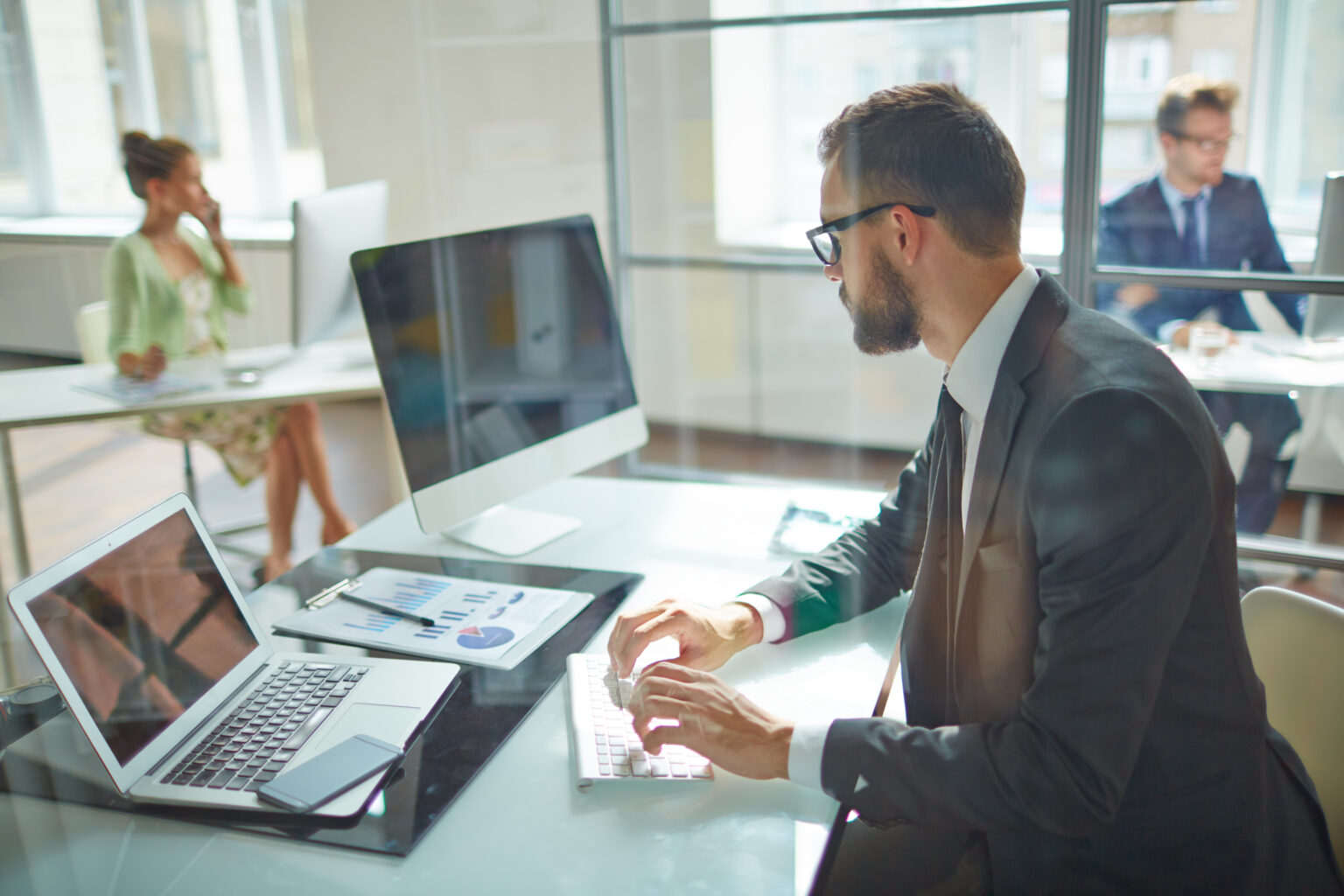 Young employee looking at computer monitor during working day in office